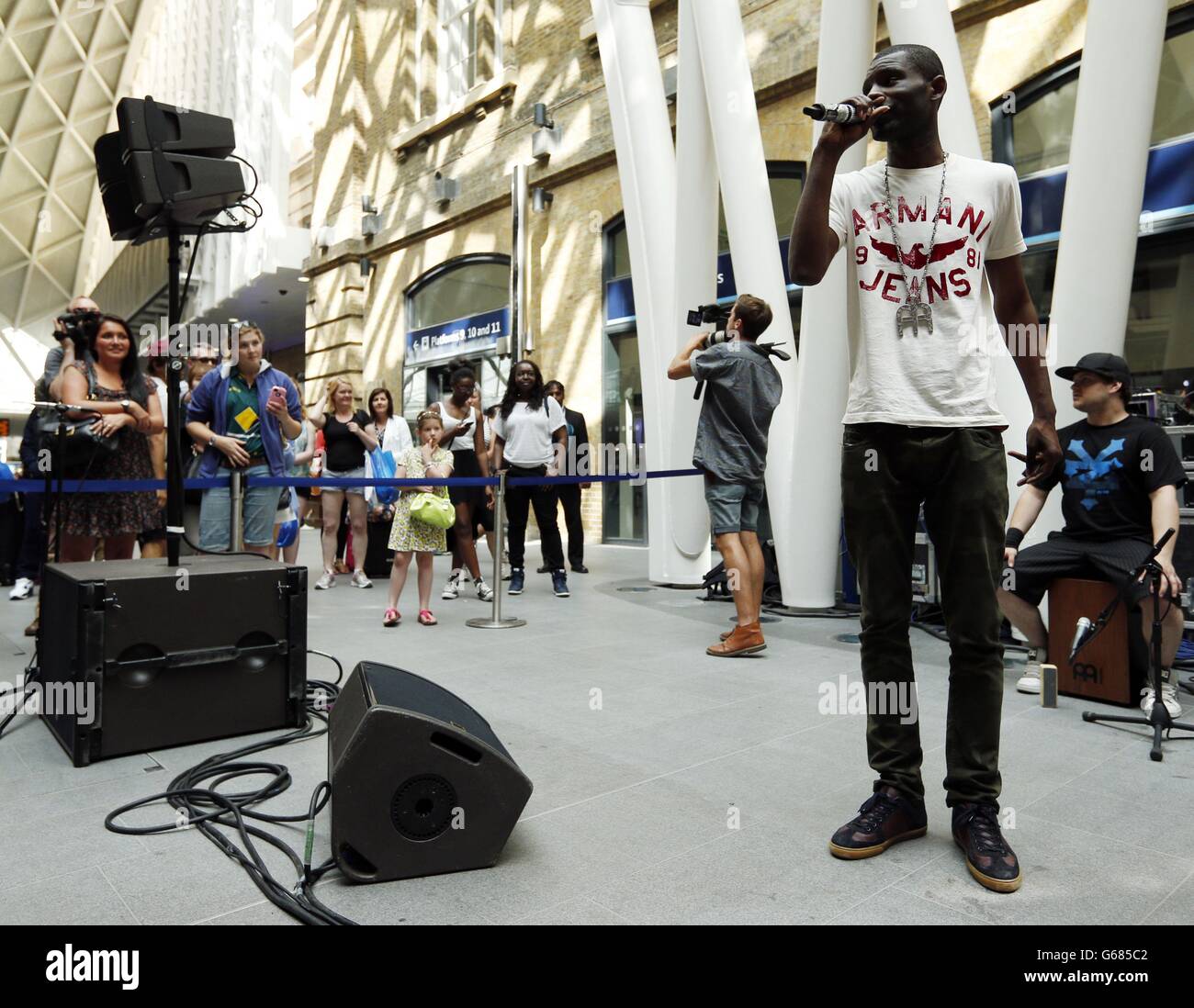 Wretch 32 performs at a surprise busking gig as part of a series of tours, all part of Yahoo! on the Road, a prelude top the Yahoo! Wireless festival at King's Cross railway station, London. Stock Photo