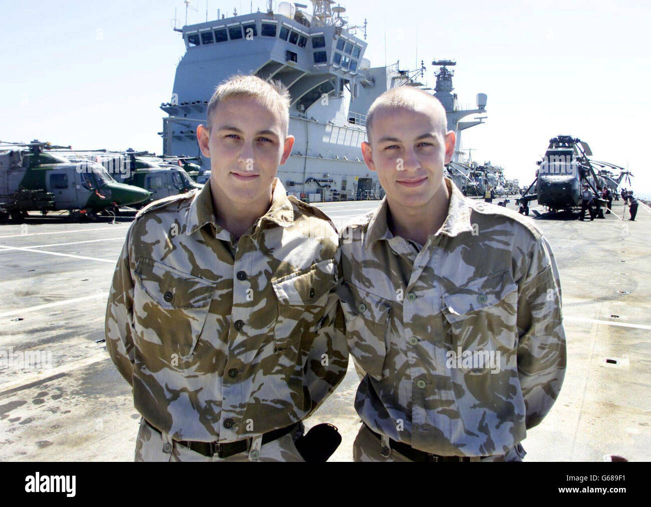 Identical twins Paul (left) and Steven Holland on board HMS Ocean in the Northern Arabian Gulf. By a stroke of chance, the sailor brothers have been stationed with exactly the same individual unit on exactly the same ship for any conflict against Iraq. * Also holding the same job and rank, the twins, from St Helens in Lancashire, both work as Air Engineer Mechanics on navy Sea King helicopters with 845 Naval Air Squadron, currently based on board the helicopter carrier. Stock Photo