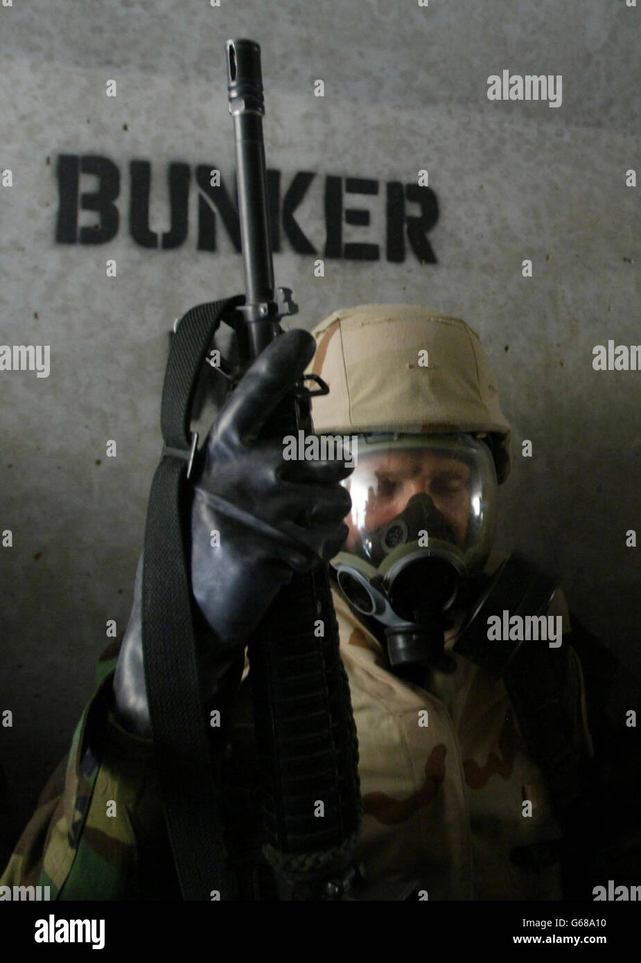 A U.S. Marine closes his eyes as he waits in a full nuclear biological and chemical protection suit in a bunker at a desert base in Kuwait after a warning of a second scud missile attack from Iraq. * Iraq fired missiles at Kuwait, prompting U.S. troops to don chemical protective suits and setting emergency air raid sirens blaring in Kuwait City. Stock Photo