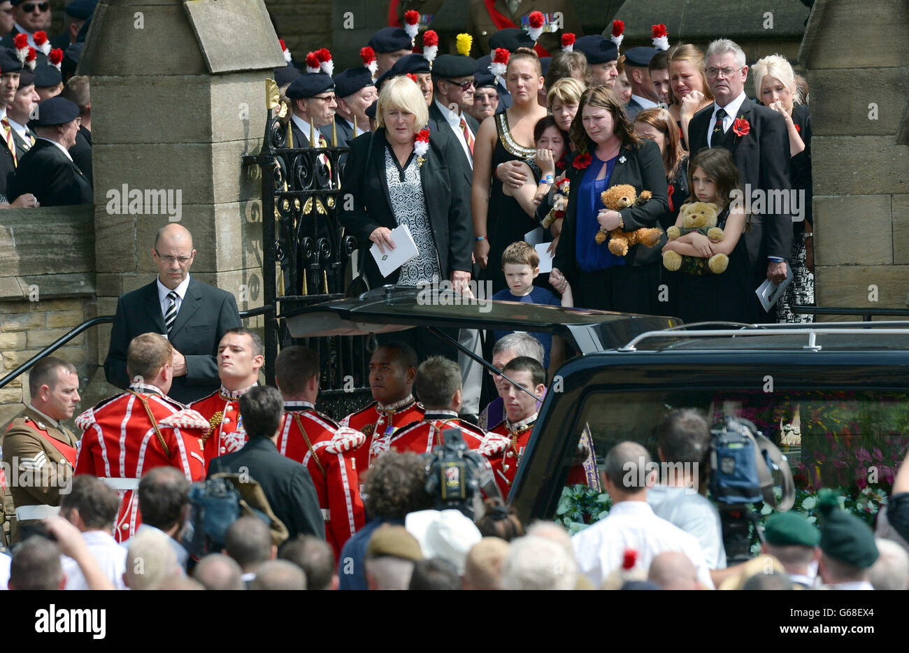 Family members watch as the coffin of murdered Fusilier Lee Rigby is carried from Bury Parish church in Greater Manchester, following his funeral service. Stock Photo