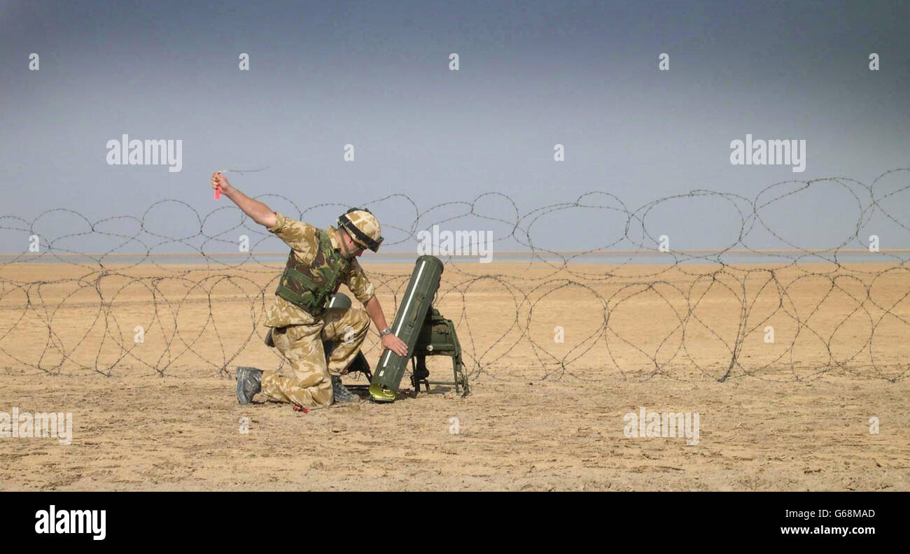 A British soldier fires a POMINS during training in the Kuwait desert. POMINS is a portable mine-neutralization system which can clear a path 50 meters long and 50 centimeters wide through anti-personnel minefields and or barbed wire entanglements. Stock Photo