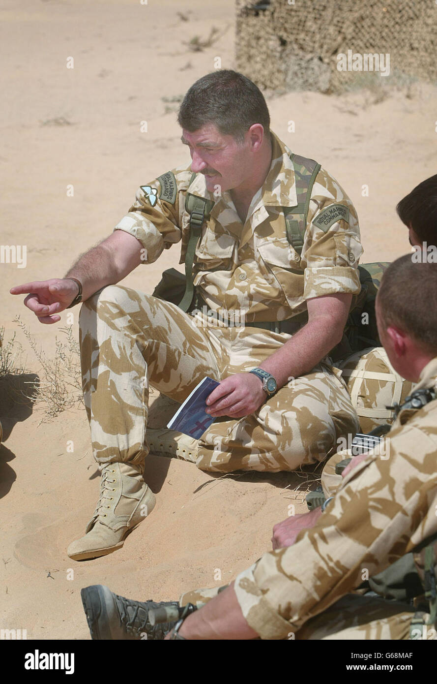 Warrant Officer 1st Class Kevin Green (2nd left), who is the Trauma Manager for the corps, talks to a group of marines (l to r) Lance Corporal Matthew Martin, * .. Lance Corporal Steve Burns and Lance Corporal Neil Fellows from HQ 3 Commando Brigade before any potential problems with Post Traumatic Stress Disorder which may arise in a possible war with Iraq, in Kuwait. The handling of the problem in this way is unique to the marine corps. Stock Photo