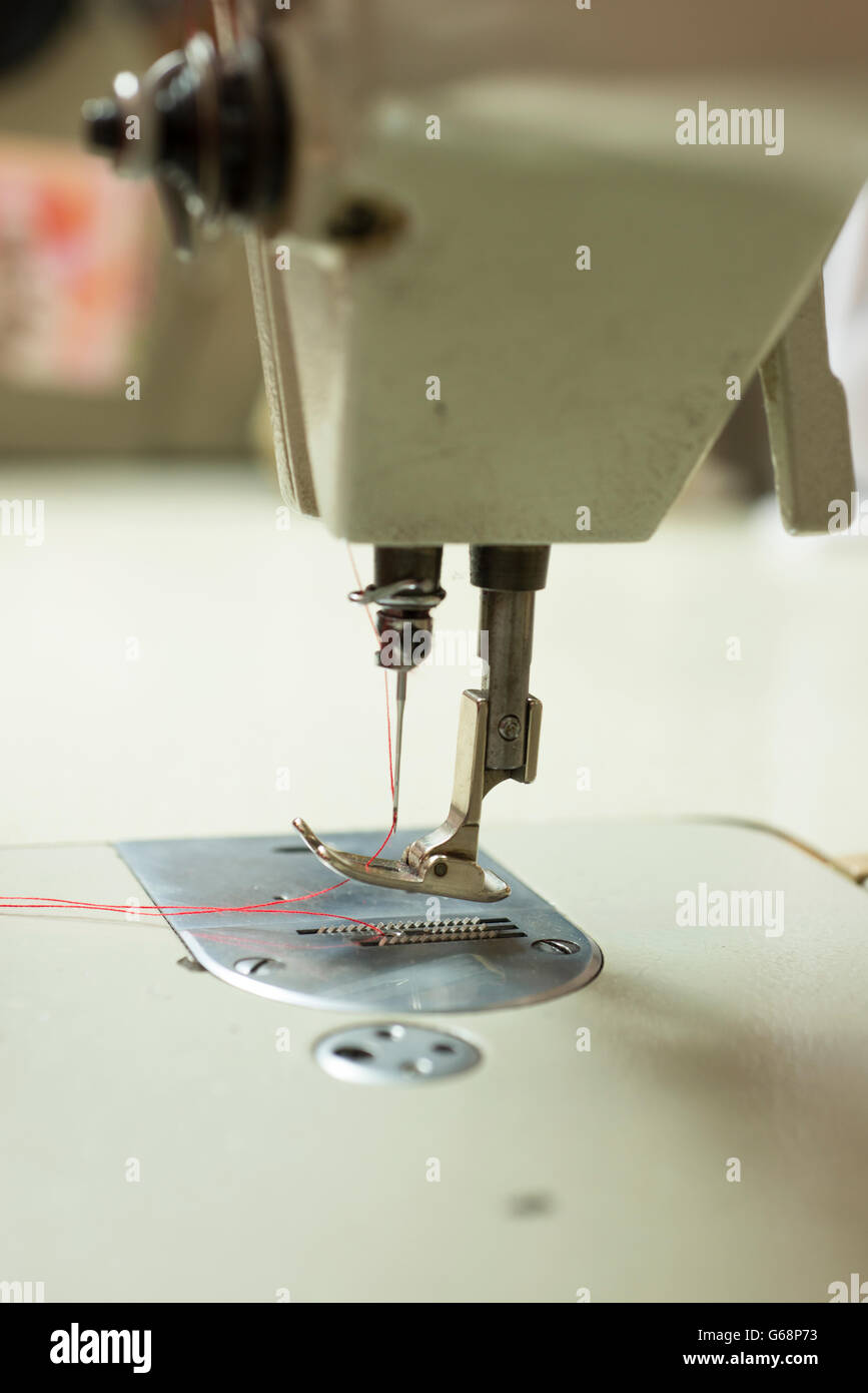 Needle threaded with red wool on sewing machine Stock Photo Alamy