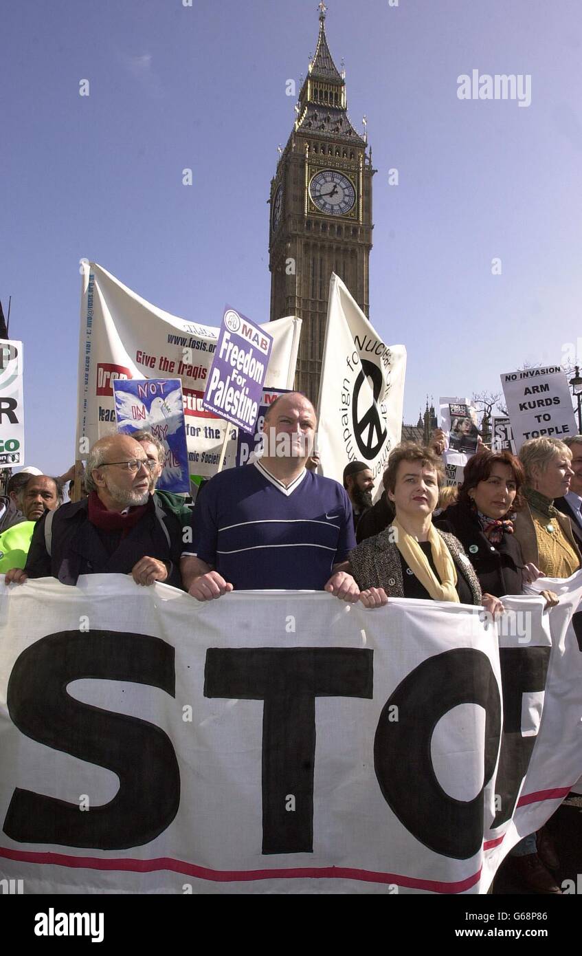 The front line of demonstrators holding placards make their way past the Houses of Parliament in London's Parliament Square during the anti-war march. Stock Photo
