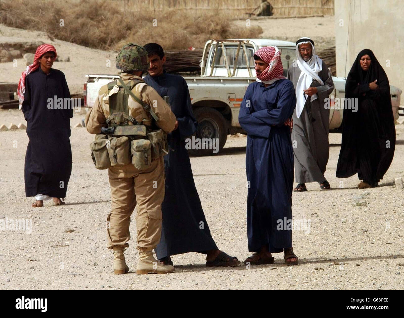 Captain Simon Ridgway, serving with the 2nd Royal Tank Regiment, talks with loCal Iraqis the British troops met after arriving in Basra. Stock Photo