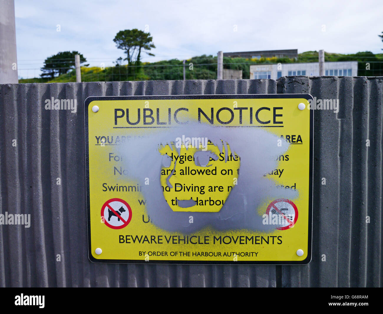 Public notice with bot grafitti face in silver paint Stock Photo