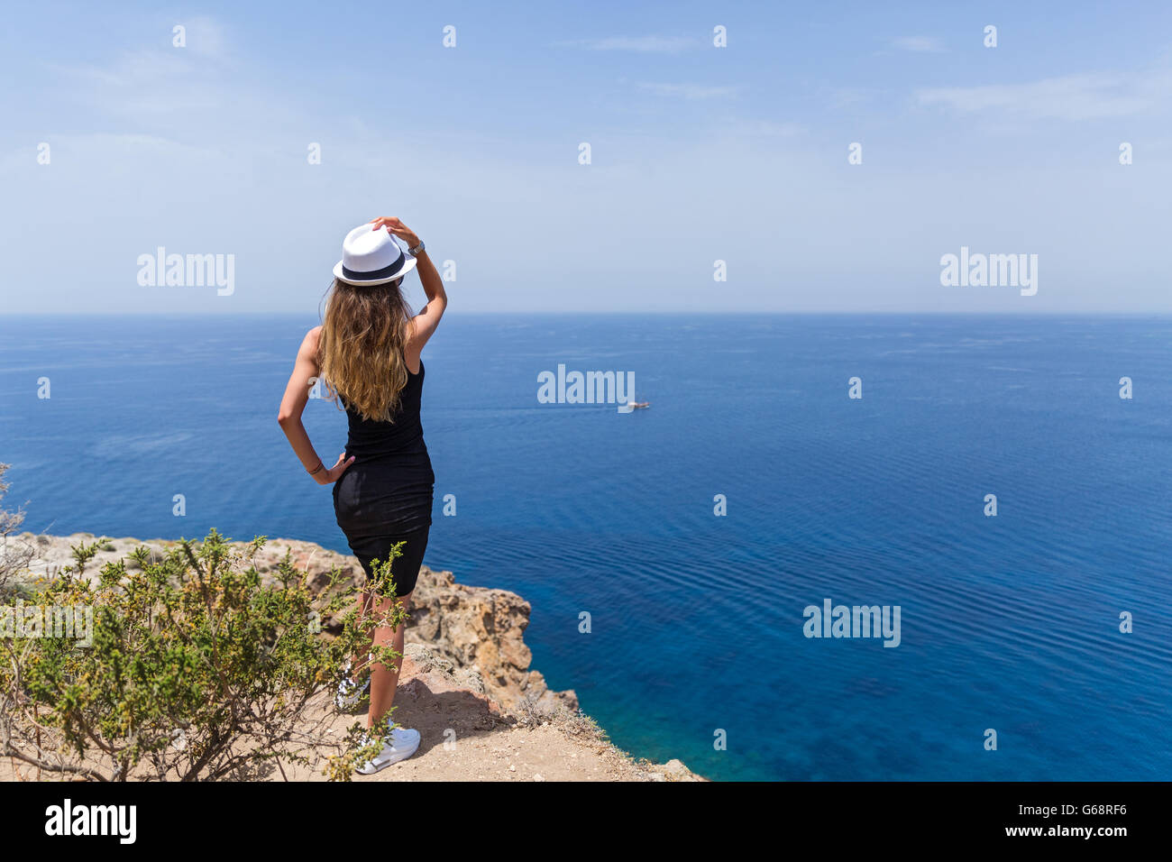 Young girl in a black dress looking at the sea Stock Photo - Alamy
