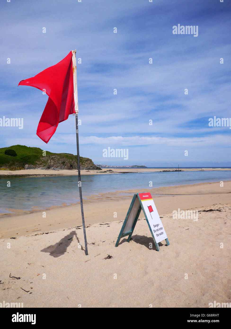 Red warning flag flying on beach Stock Photo