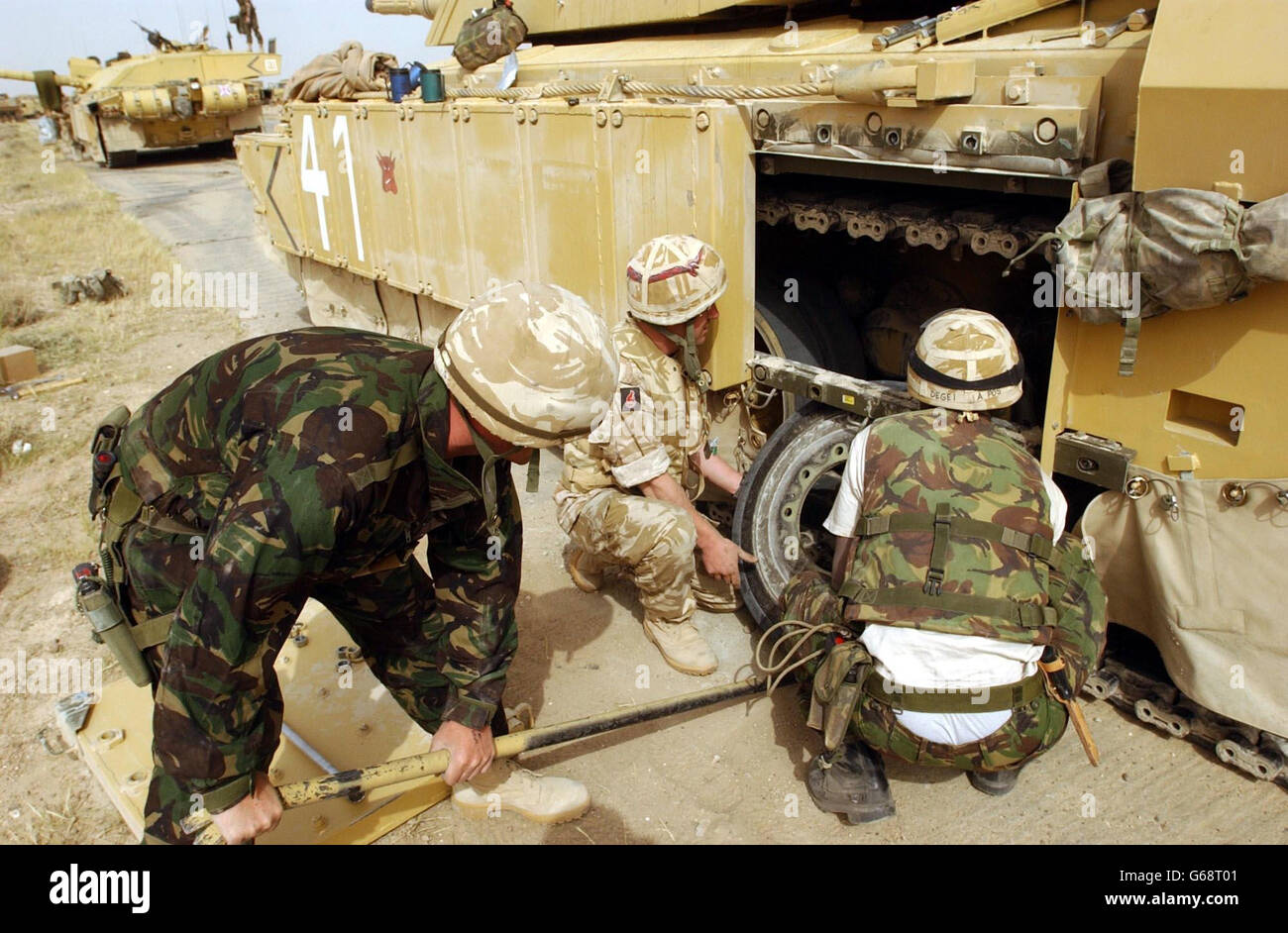 Servicemen from the Royal Scots Dragoon Guards change the wheel on a Challenger II tank near Basra in Iraq. British commanders were trying to establish the extent of the Iraqi opposition in Basra after a night's brief uprising against Saddam Hussein's feared security service. * While there were reports of continued skirmishing on the outskirts, military sources said that there were no immediate plans by UK forces. Stock Photo
