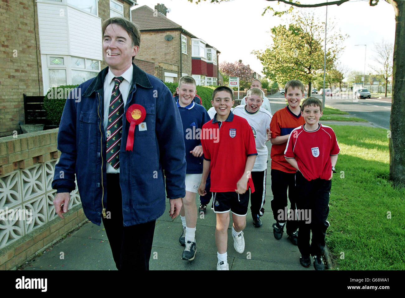 Peter Mandleson MP right canvasing from door to door in his constituency of Hartlepool in County Durham, N E England, for the British 2001 general election. He later became European Commissioner for Trade (2004 and 2008) and was made a life peer. Peter Mandleson gathers a following of youngsters, Pied Piper style. Stock Photo