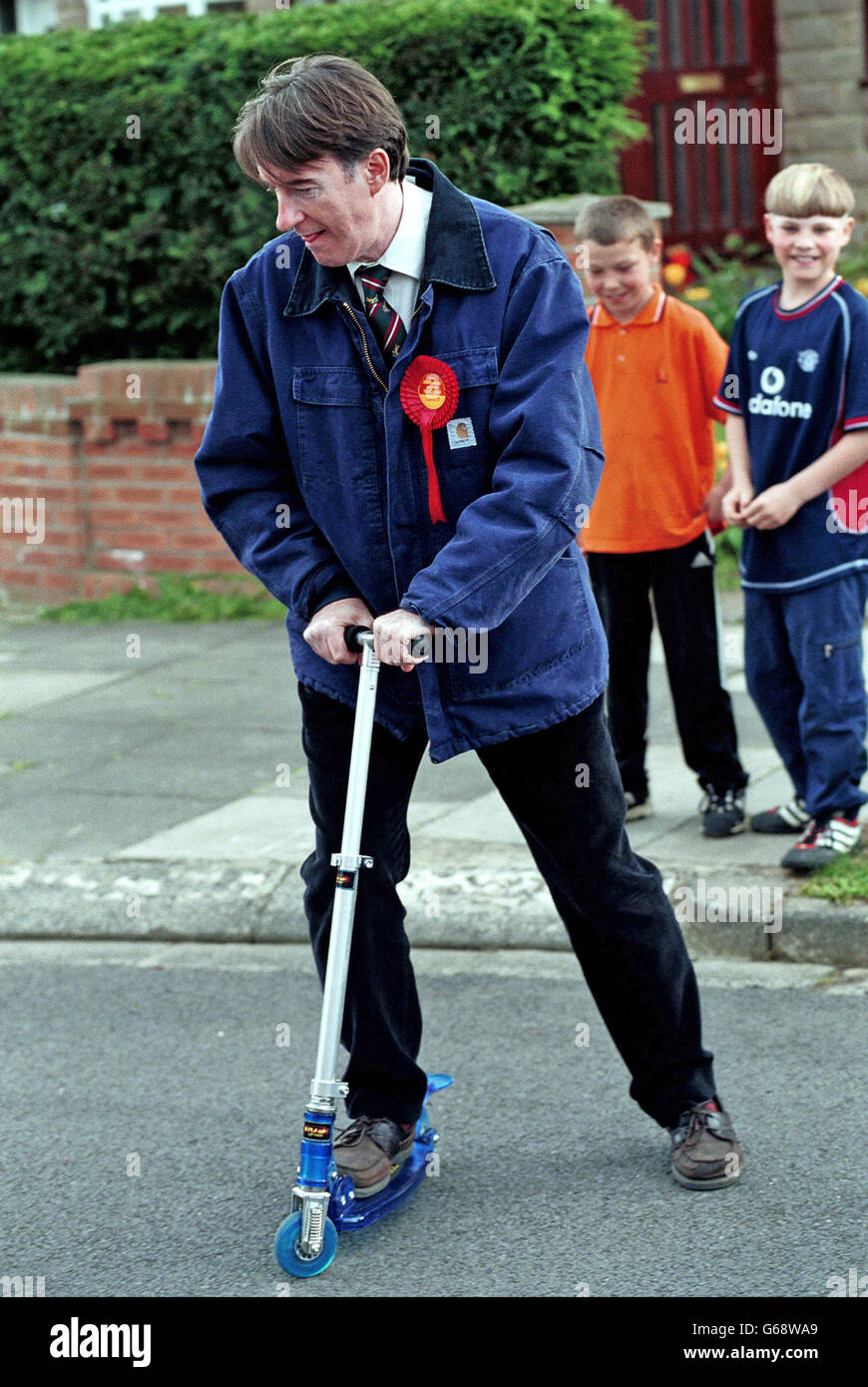 Peter Mandleson MP right canvasing from door to door in his constituency of Hartlepool in County Durham, N E England, for the British 2001 general election. He later became European Commissioner for Trade (2004 and 2008) and was made a life peer. Peter Mandleson tries out a mini scooter borrowed for a moment from to passing children. Stock Photo