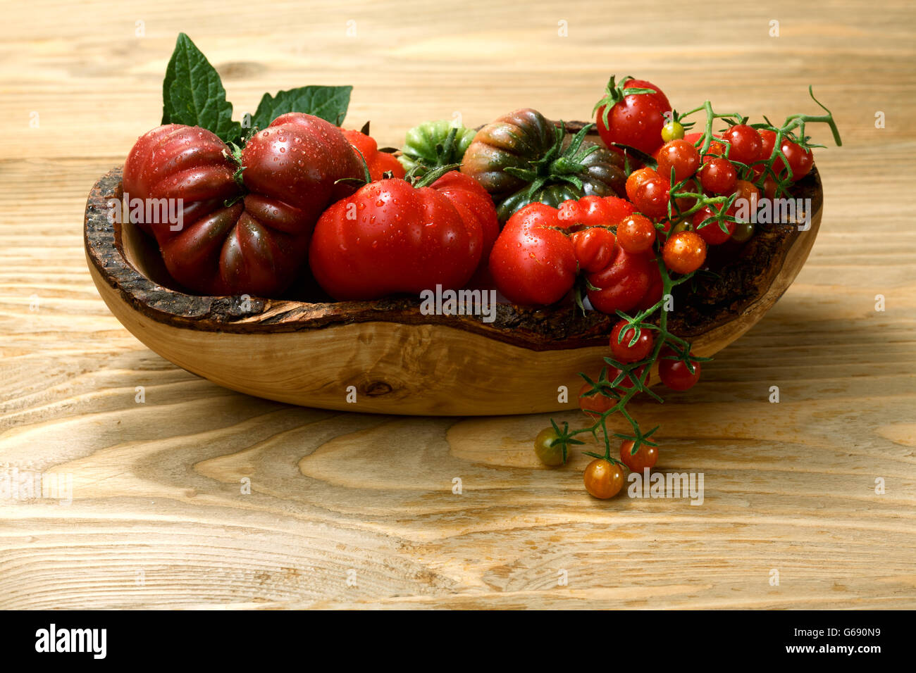 Biodiversity. Fresh heirloom tomatoes on wooden table. Selective focus. Organic food Stock Photo