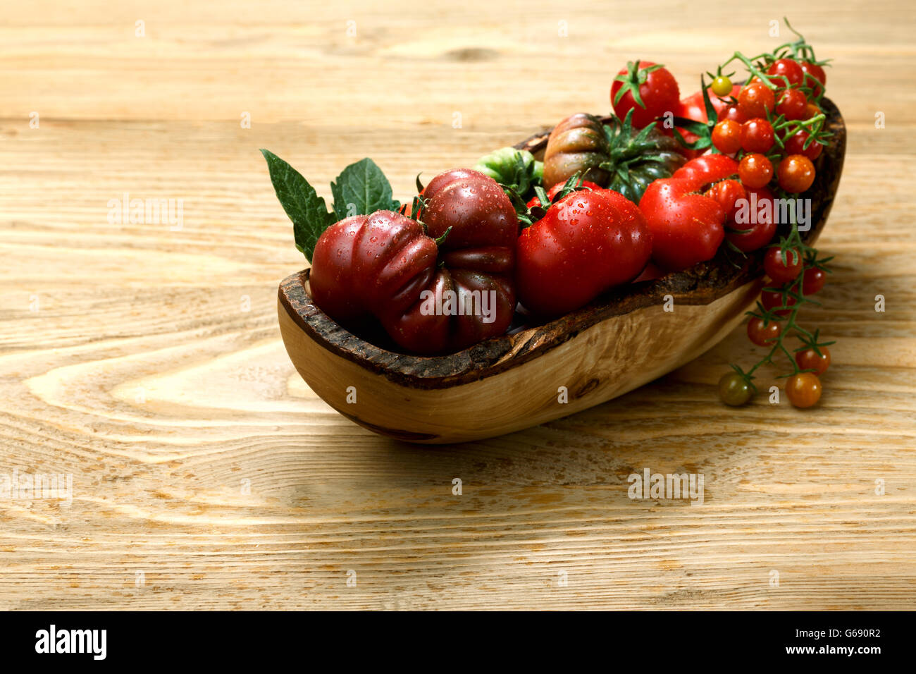 Biodiversity. Fresh heirloom tomatoes on wooden table. Selective focus. Organic food Stock Photo