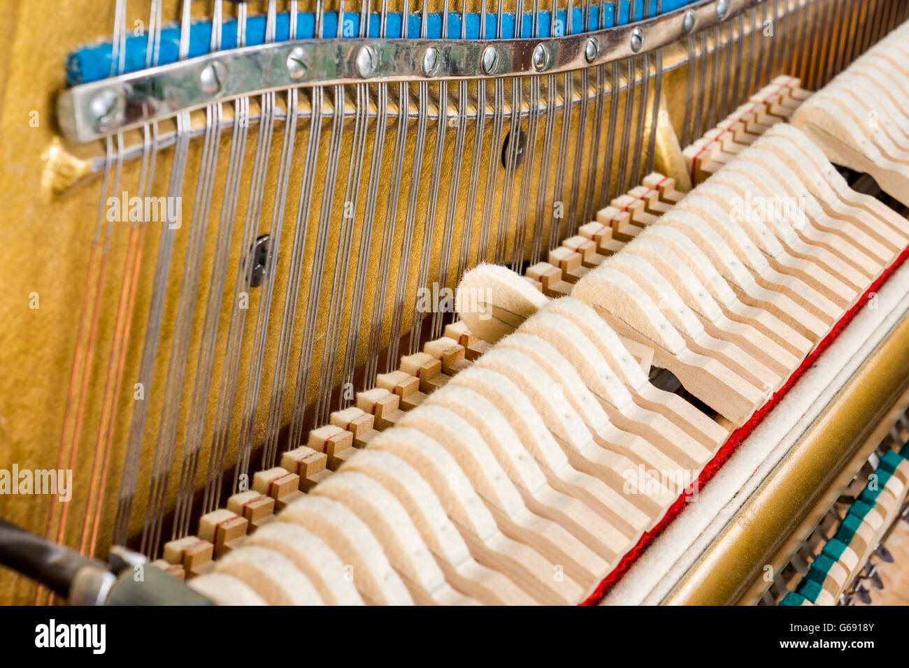 Pattern of hammers and strings inside piano, close up. One hummer in action while key is pressed. Stand out from the crowd conce Stock Photo