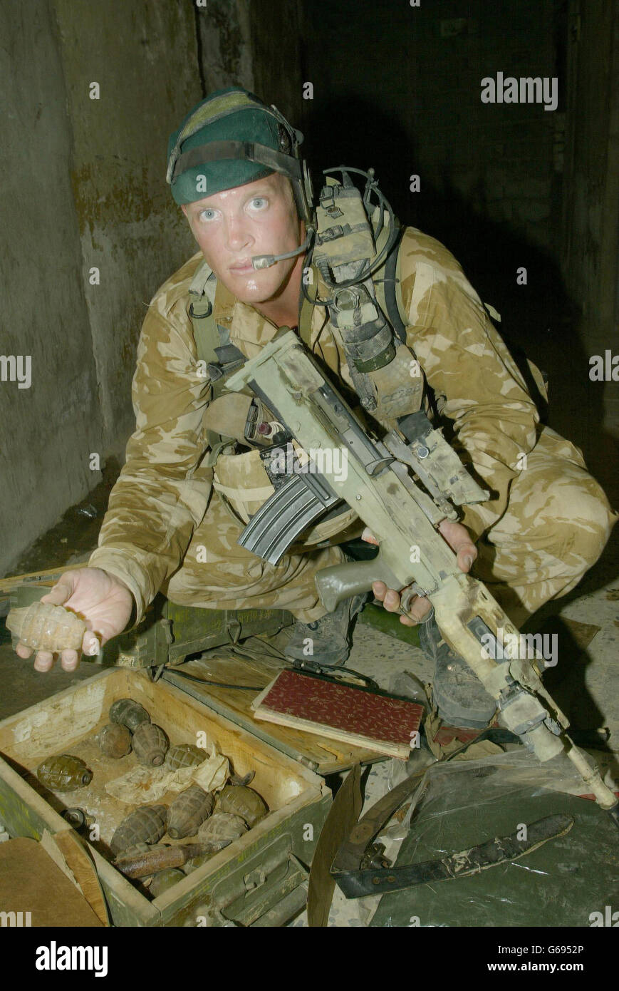 Corporal Dominic Conway of 40 Commando Royal Marines, holds an old grenade left behind by Iraqi forces in an interrogation centre in Abu Al Khasib. Stock Photo