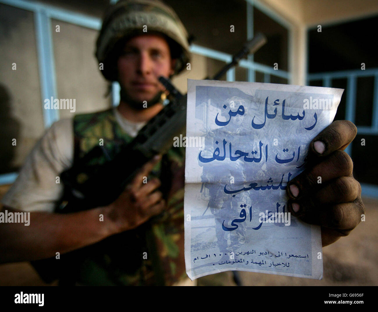 A British soldier holds a leaflet in Arabic issued to British troops telling potential Iraqi prisoners of war how to act. Concerns have been raised that the British Army has few translators able to converse with local Iraqi populations. Photo by Dan Chung, The Guardian, MOD Pool Stock Photo