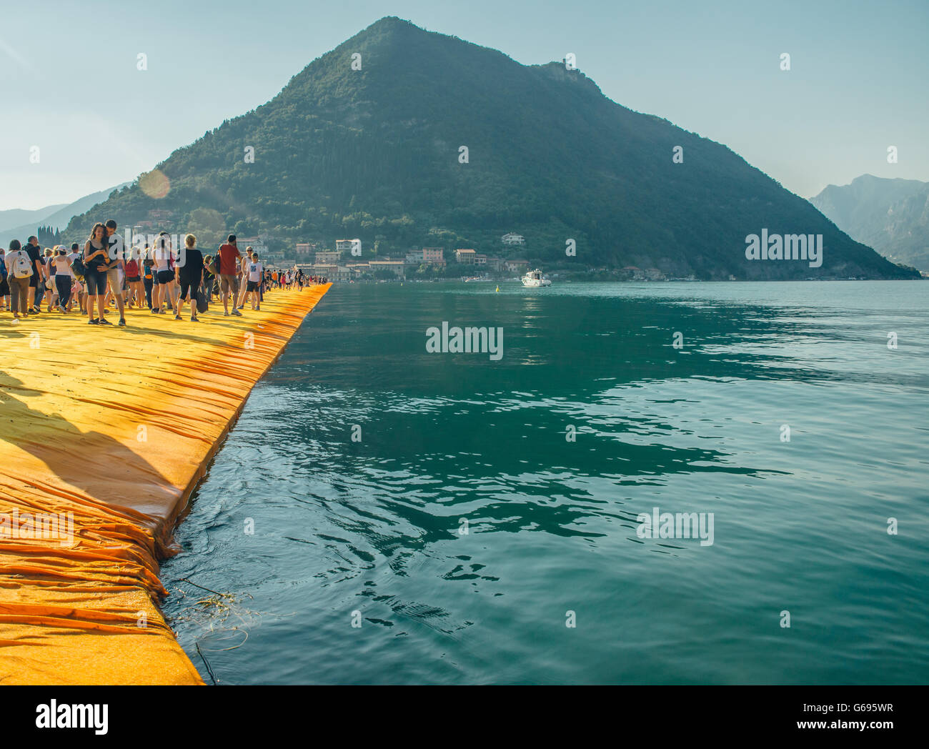 The Floating Piers Christo project. Visitors walking from Sulzano to Monte Isola and to the island of San Paolo. Stock Photo