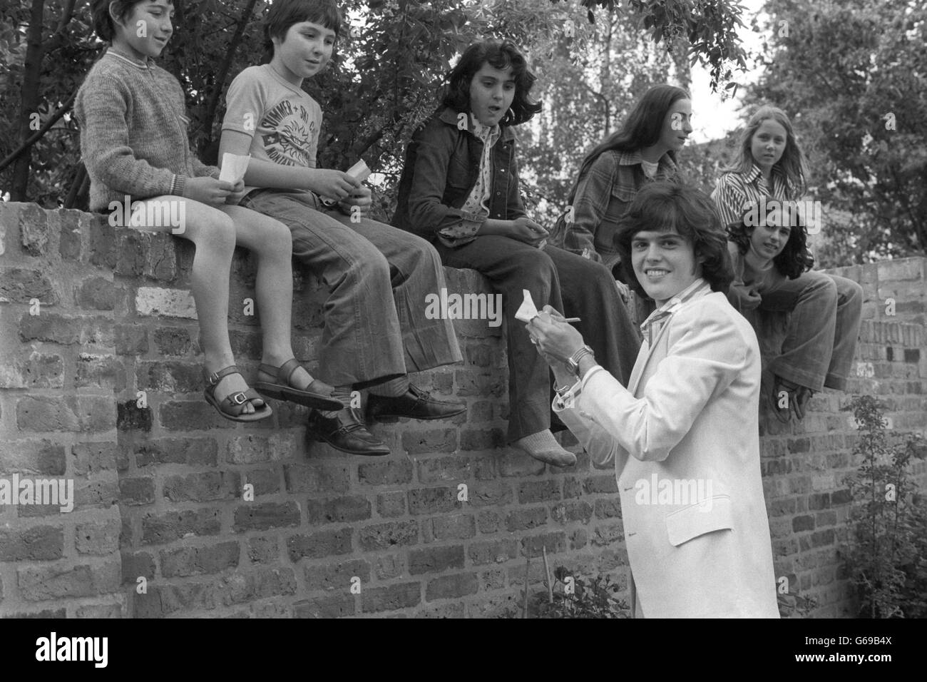 Fans of the Osmond Brothers' pop group, who gate-crashed a garden party held in honour of the group at the Richmond Fellowship in Addison Road, London, were rewarded with autographs from Donny Osmond. Stock Photo
