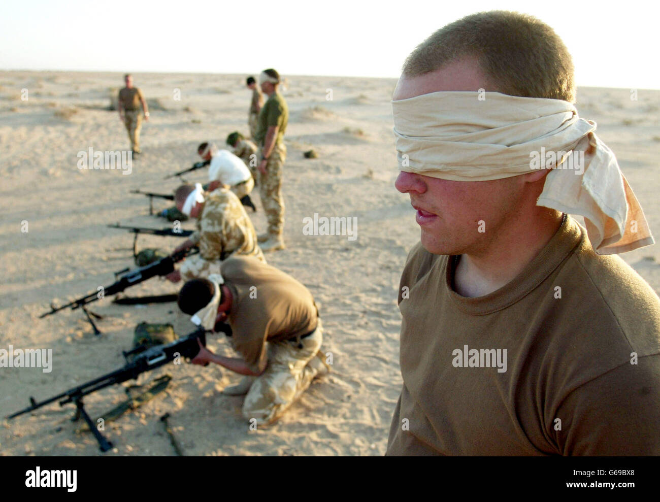British troops from 29 Commando Regiment Royal Artillery train in stripping and assembling a General Purpose Machine Gun blindfold in the Kuwait desert near the Iraq border. Stock Photo
