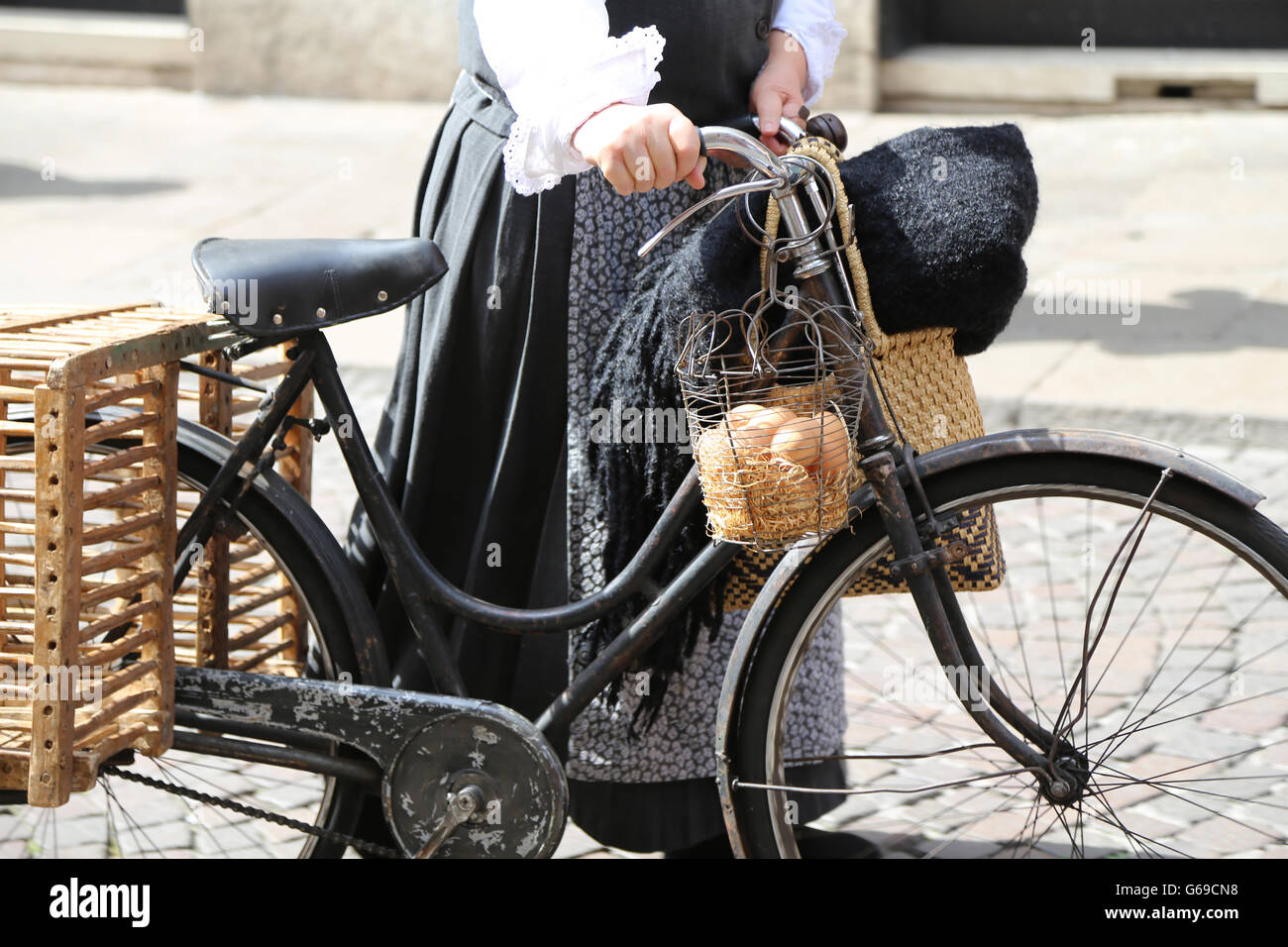 elderly woman on bicycle with a basket full of fresh eggs Stock Photo