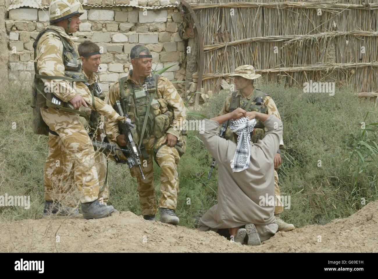 Men from 40 Commando Royal Marines take a prisoner, believed to be Iraqi army who provided them with information on the location of the Ba'ath Party headquarters in the town of Al Faw in Southern Iraq. Stock Photo