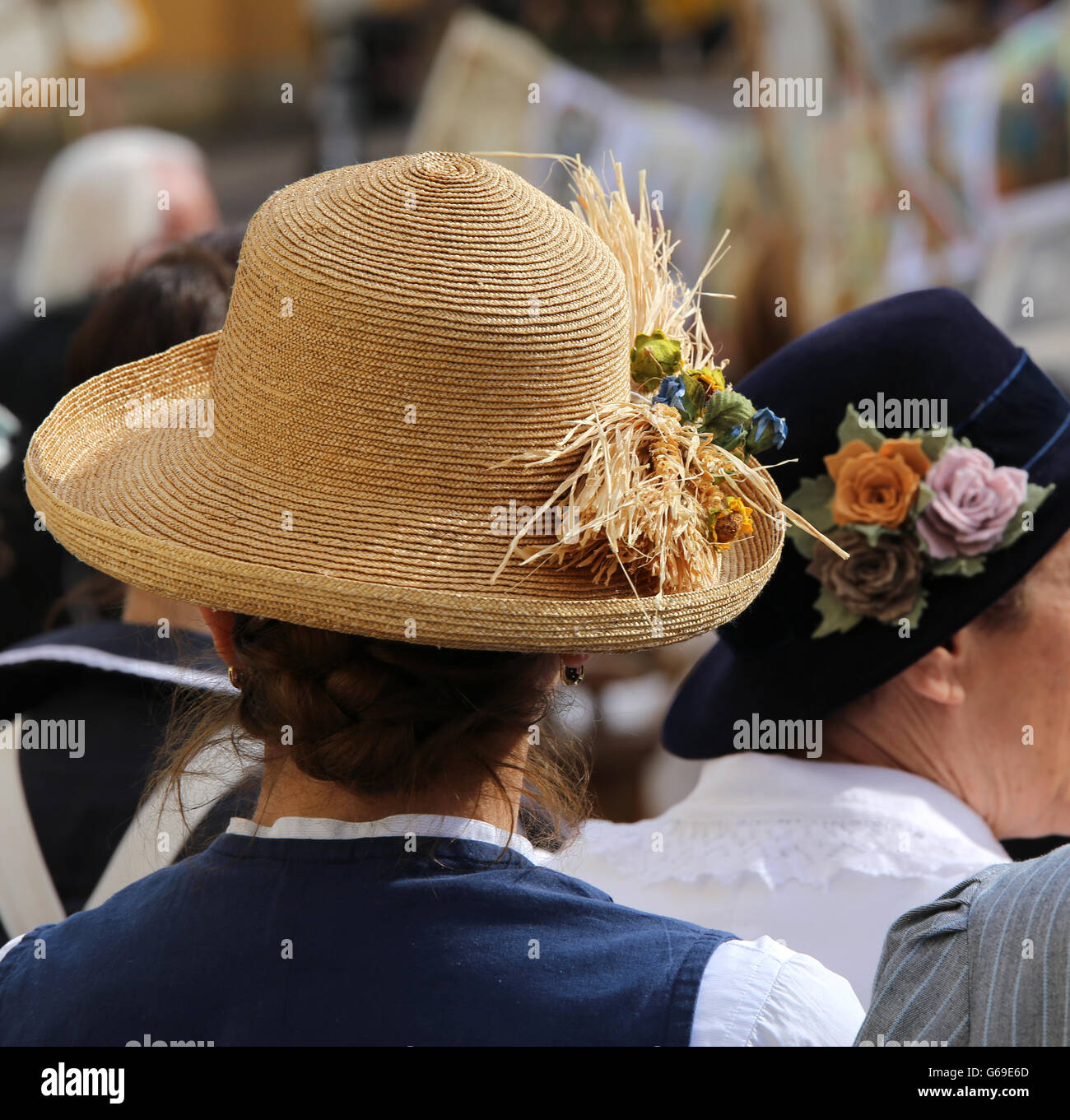 woman with yellow hat with ears of corn in a crowd Stock Photo