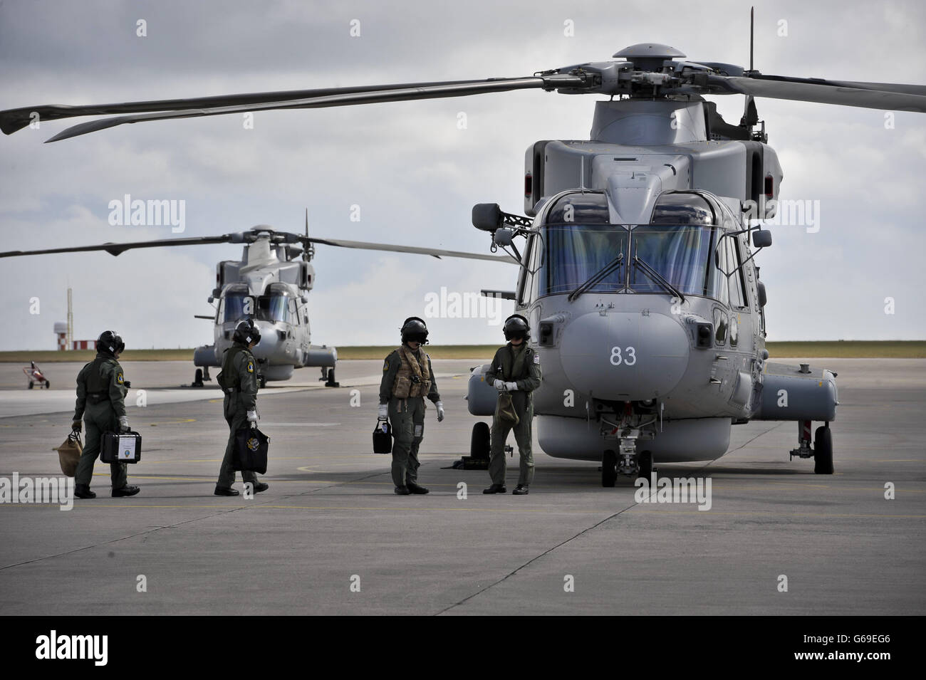 Aircrew make their way to a Merlin Mk 2 aircraft at Royal Naval Air Station Culdrose, Cornwall, where the first of the UK's fleet of next generation anti-submarine maritime patrol Merlin helicopters have been handed over to the Royal Navy. Stock Photo