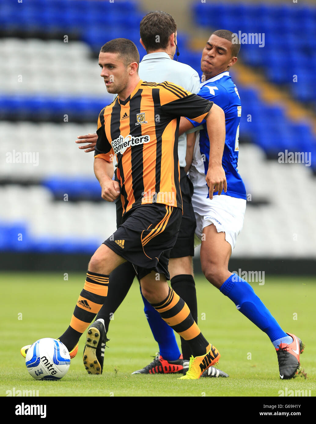 Soccer - Friendly - Birmingham City v Hull City - St Andrews. Referee David Coote gets sandwiched between Birmingham City's Tom Adeyemi and Hull City's Robbie Brady Stock Photo