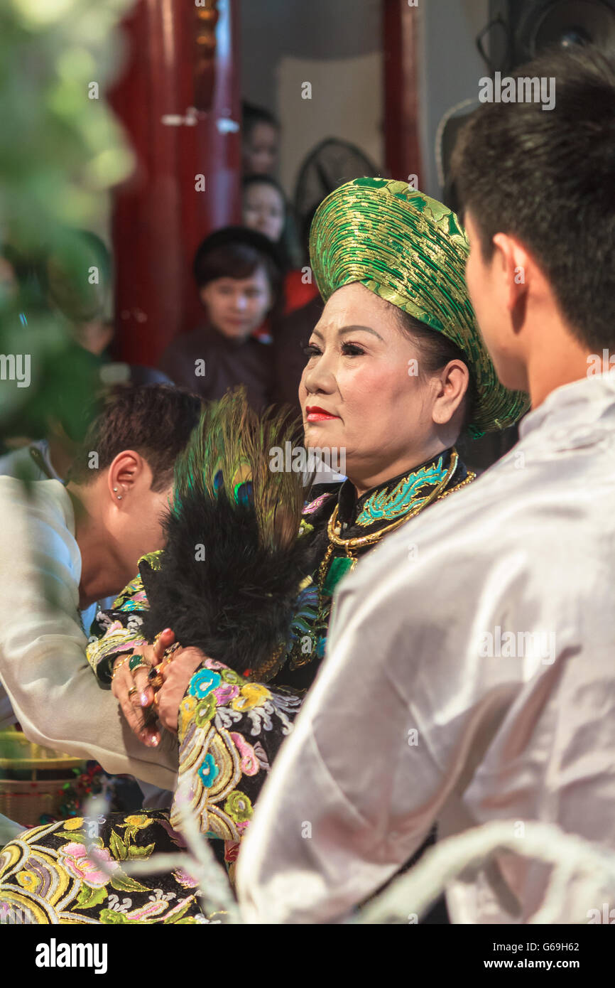 Female medium being dressed up for spirit mediumship ritual in Vietnam Stock Photo