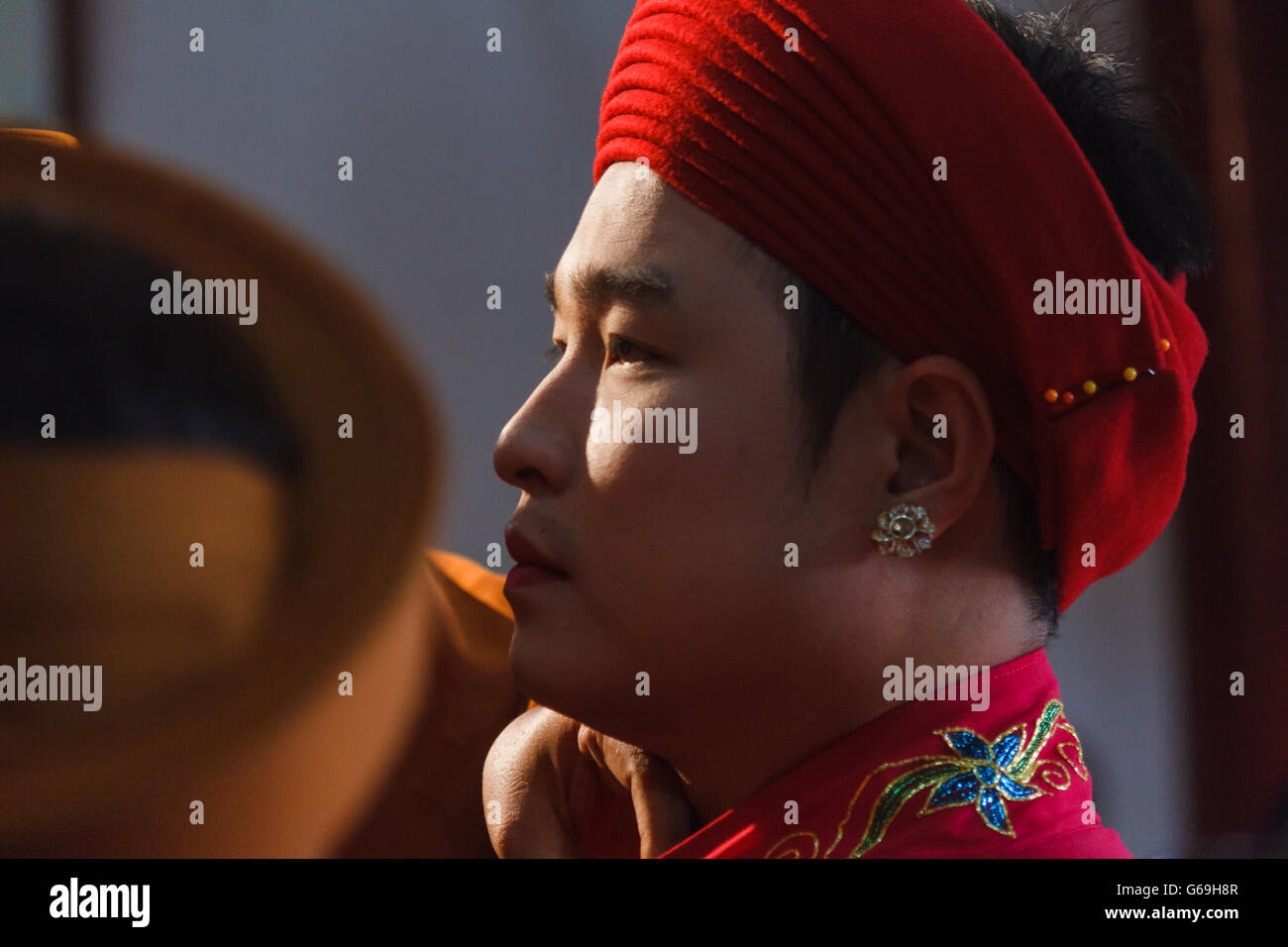 A male medium is dressed up and about to perform Len Dong, a spirit mediumship ritual in Central Vietnam. Stock Photo