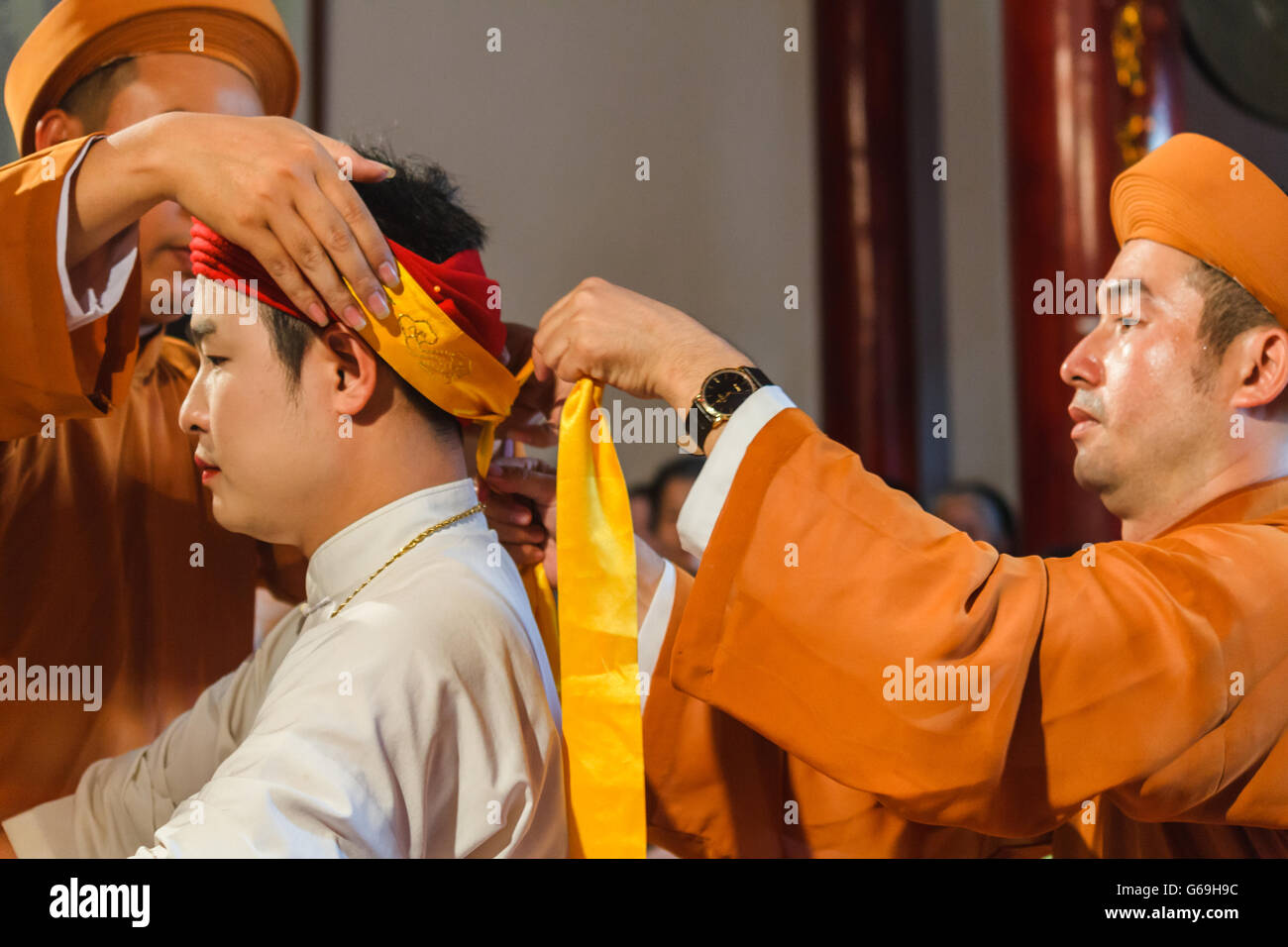 Medium being dressed up for spirit mediumship ritual in Vietnam Stock Photo