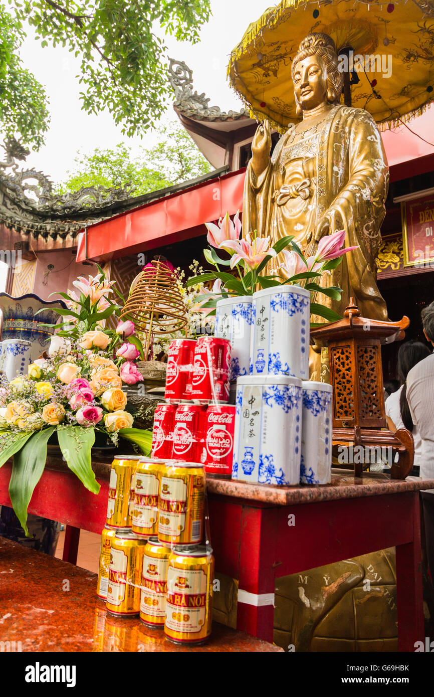Offerings in front of Guanyin statue at Vietnamese temple Stock Photo