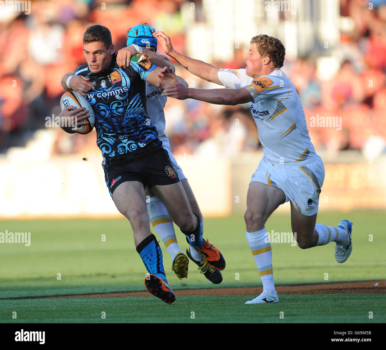 Exeter Chiefs 7's Chris Elder is tackled by Worcester Warriors 7's Richard De Carpentier and Max Stelling during the Group A match of the J.P. Morgan Asset Management Premiership Rugby 7's at Kingsholm Stadium, Gloucester. Stock Photo