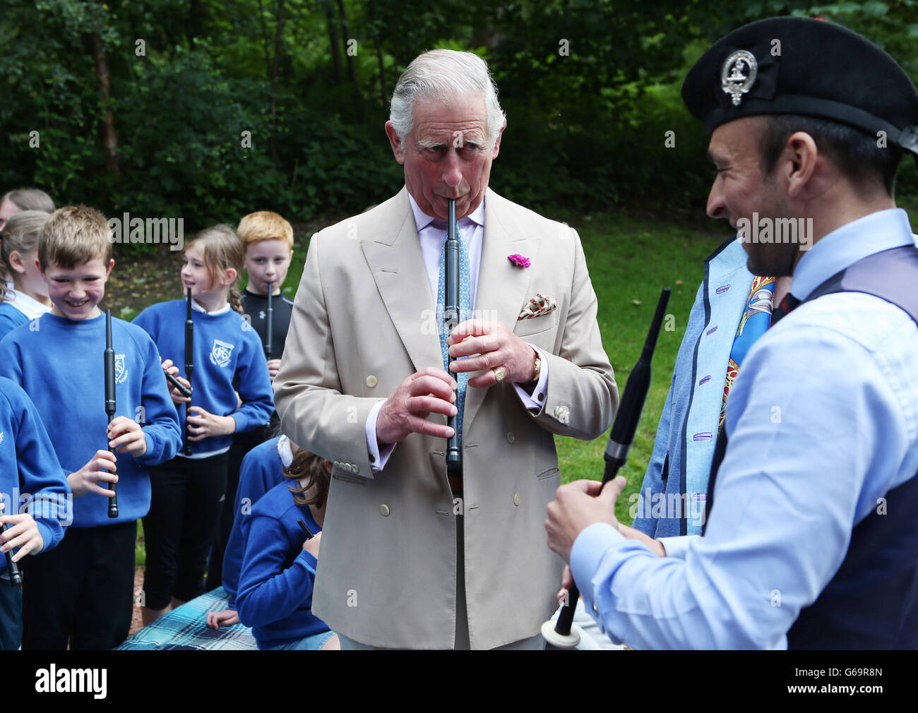 The Prince of Wales, known as the Duke of Rothesay while in Scotland, plays a chanter as he takes part in chanter lesson with local school children taught by Alisdair McLaren during his visit to the National Piping Centre at the Dumfries House Estate in Cumnock as it holds a 'Come and Try' workshop. Stock Photo