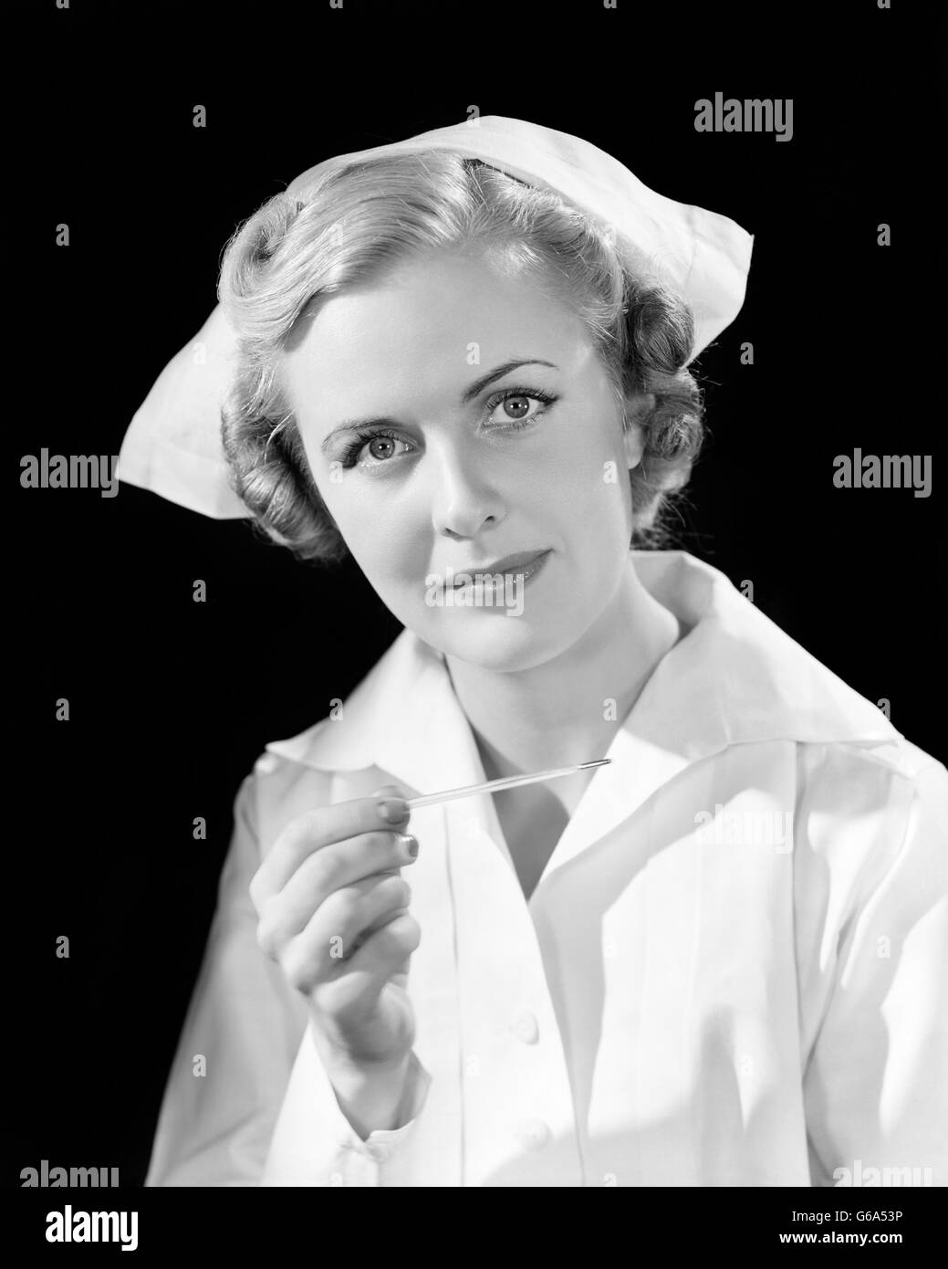 1930s PORTRAIT WOMAN  NURSE HOLDING THERMOMETER LOOKING AT CAMERA Stock Photo