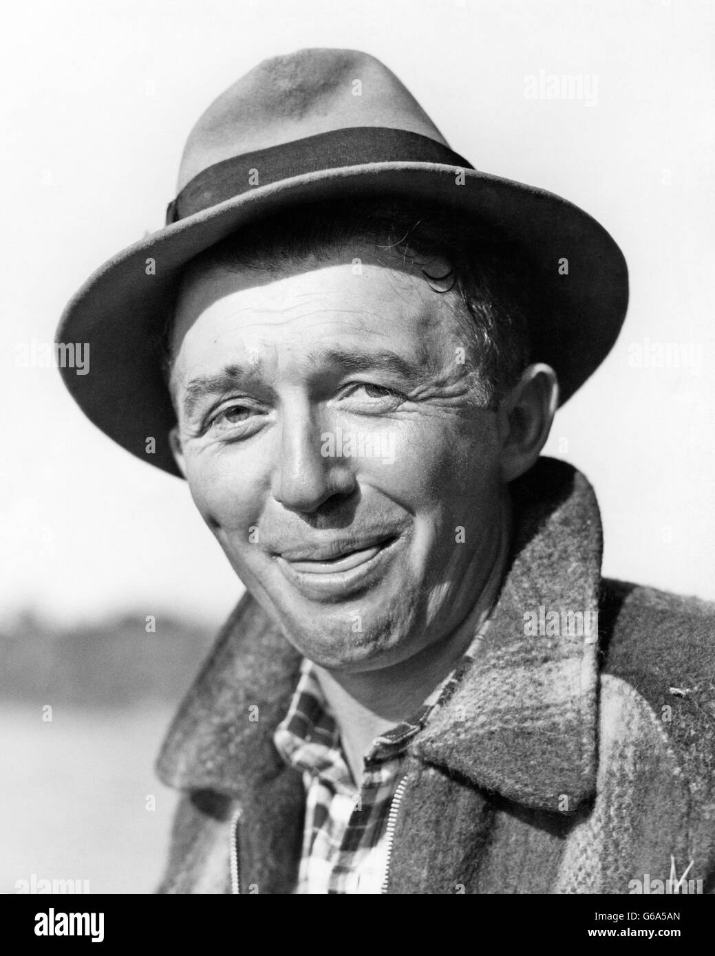 1930s PORTRAIT MAN WEARING HAT SMILING EYES LOOKING AT CAMERA TONGUE STICKING OUT LICKING HIS LIP FUNNY FACIAL EXPRESSION Stock Photo