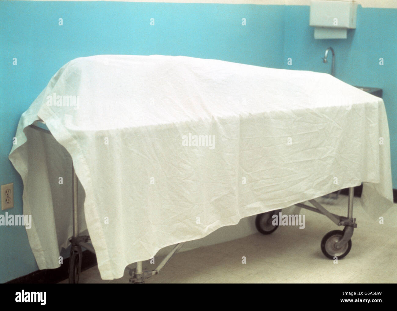 SHEET DRAPED OVER DEAD BODY ON GURNEY IN MORGUE Stock Photo