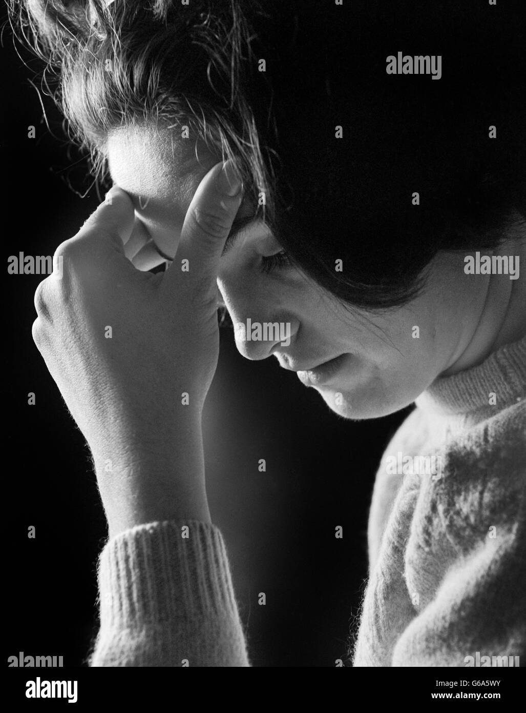 1960s 1970s WOMAN HOLDING HER FOREHEAD IN HER HAND HEADACHE TIRED DEPRESSED SAD Stock Photo