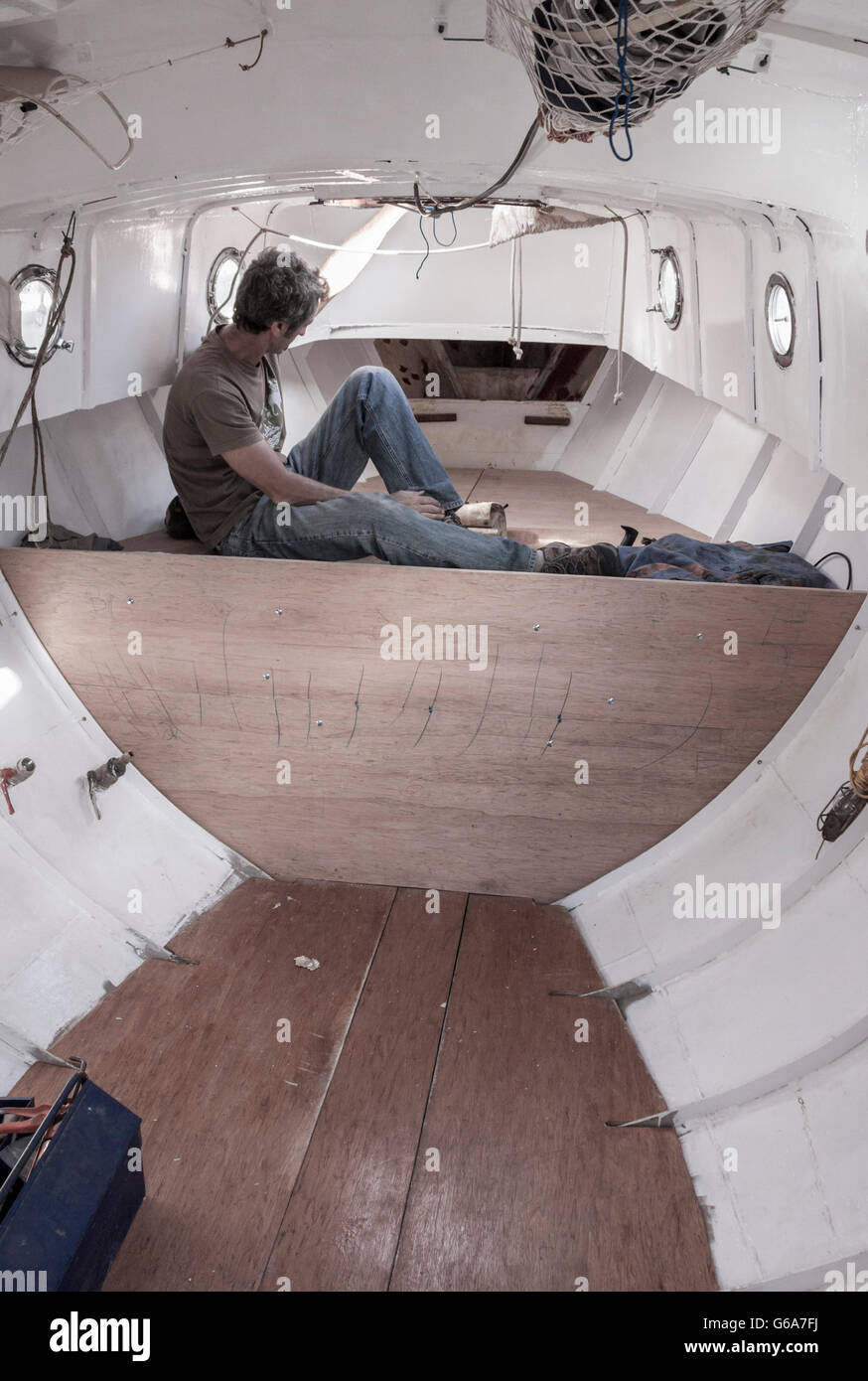 Man Refitting Interior Of Steel Hulled Small Yacht Stock