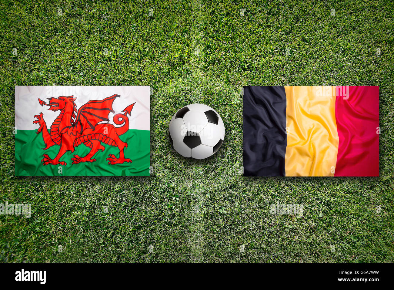 Wales vs. Belgium flags on green soccer field Stock Photo