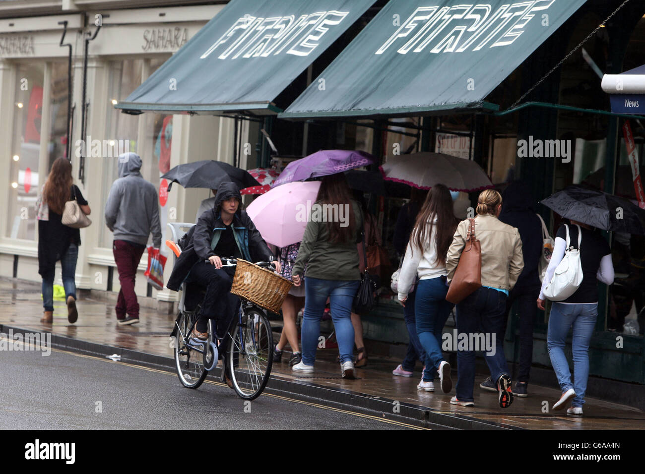Tourists brave the summer rain while visiting Oxford. Stock Photo