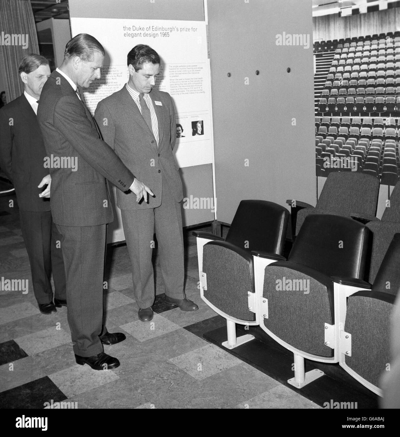 Prince Philip, The Duke of Edinburgh, pointing out features on an auditorium seat to its designer, Mr. Peter Dickinson, before the Duke presented him with his prize for Elegant Design, 1965 The auditorium seating was made by Race Contracts Ltd. Stock Photo