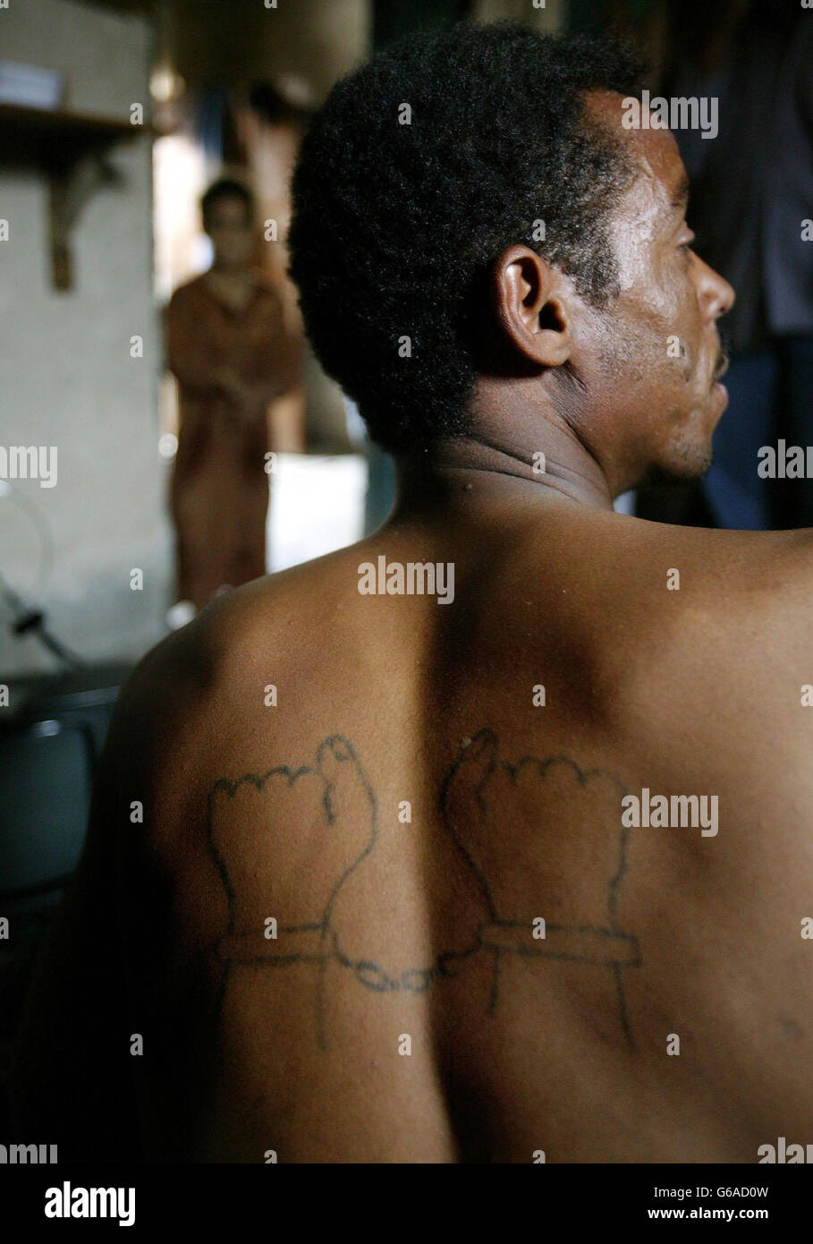 Torture victim Abdul Kareem Kassim in Shuhaba, southern Iraq, shows off the tattoo forcibly cut into his back by Saddam Hussein regime's prison guards. Dan Chung/Guardian/MOD Pool. Stock Photo