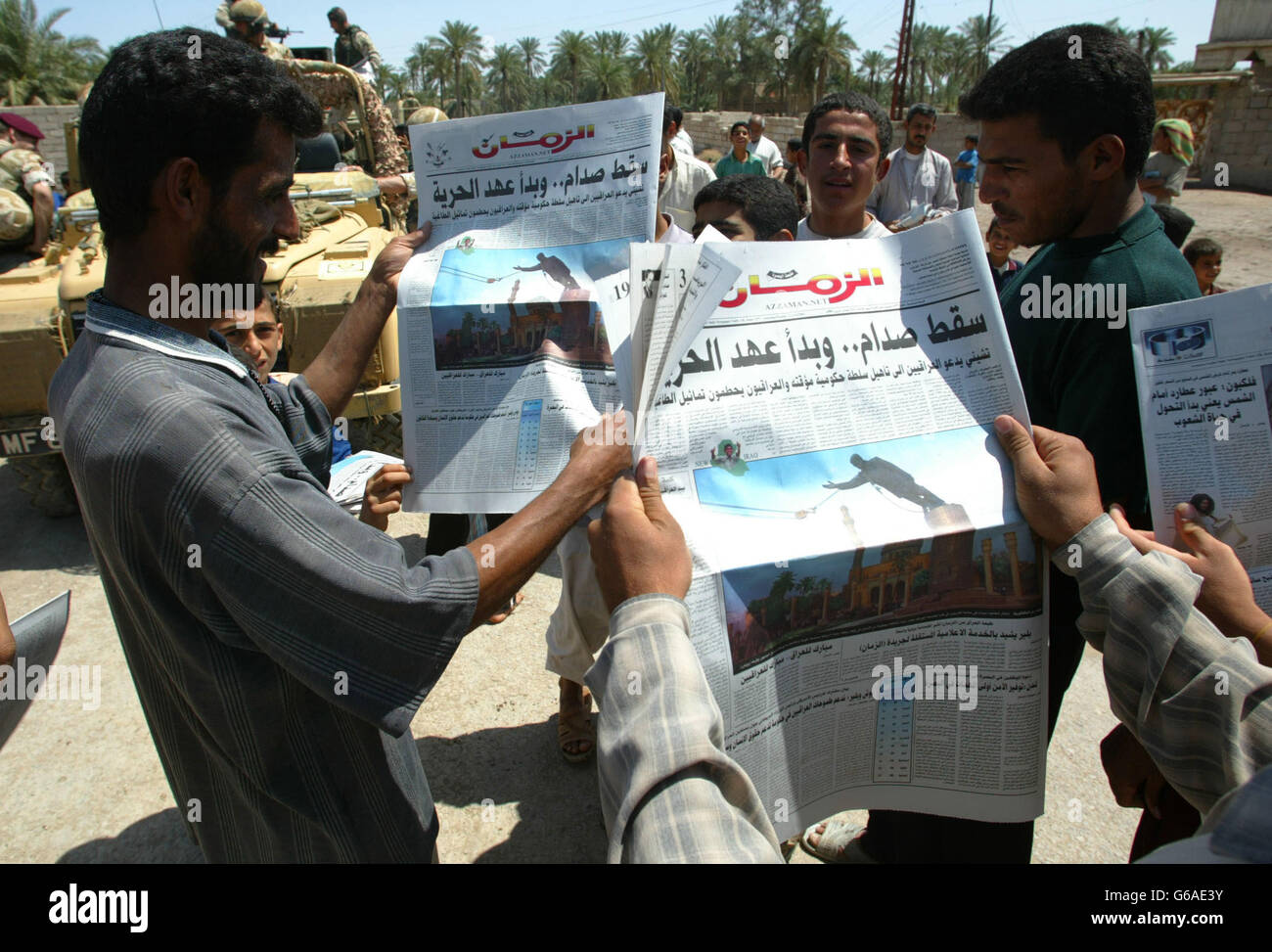 Iraqi people read a newspaper distributed in and around al Qurna by a
