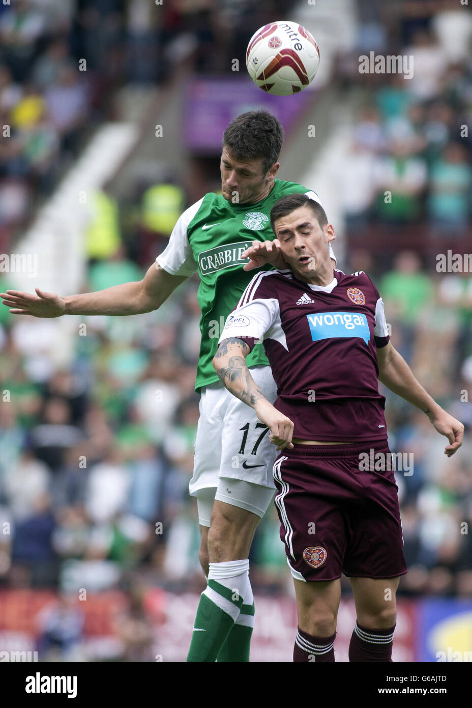 Hearts' Jamie Walker and Hibernian's Owain Tudor Jones (left) jump for the ball during the Scottish Premiership match at Tynecastle Stadium, Edinburgh. Stock Photo