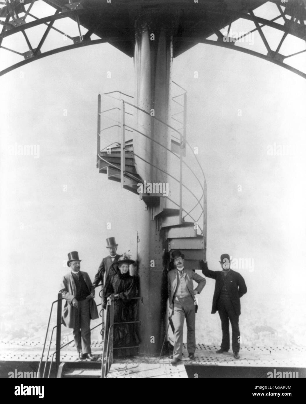 Gustave Eiffel and four other people at the summit of the Eiffel Tower at the time of the Paris Exposition Universelle in 1889, for which the tower was built. Stock Photo