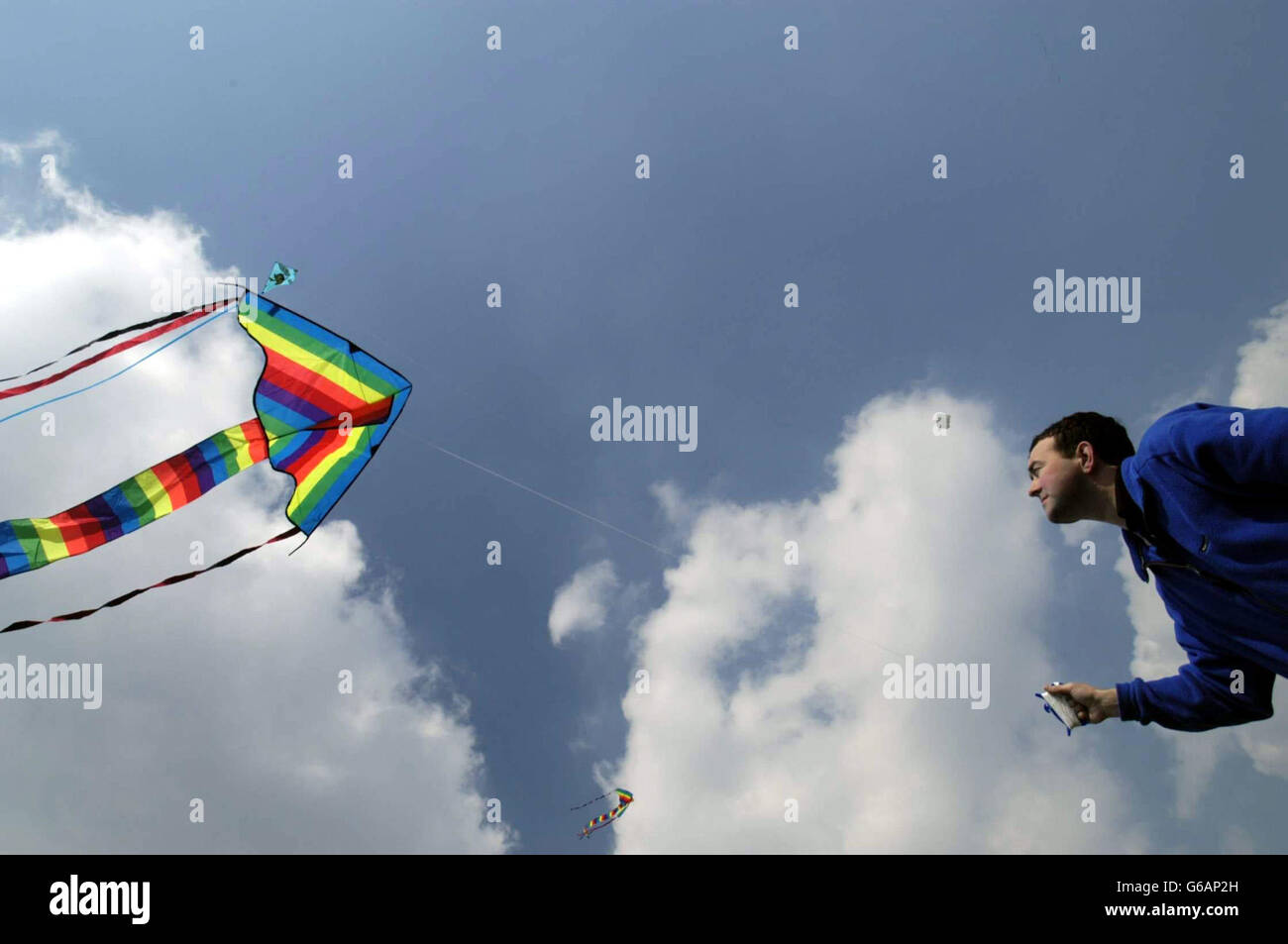 Danny Keogh reels in his son Jamie's (age 2) kite at The 6-th Streatham Common Kite Day, Streatham Common. Stock Photo