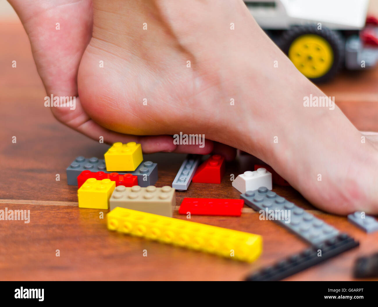 Someone step on legos for kids, various colored blocks. Pain in the heel Stock Photo