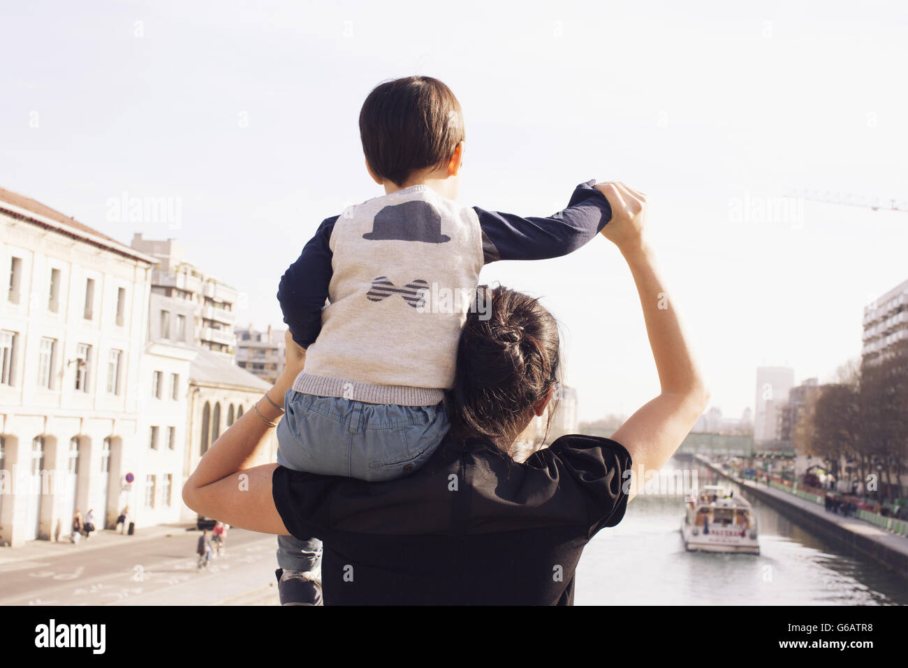 Mother carrying little boy on shoulder, looking at view together Stock Photo