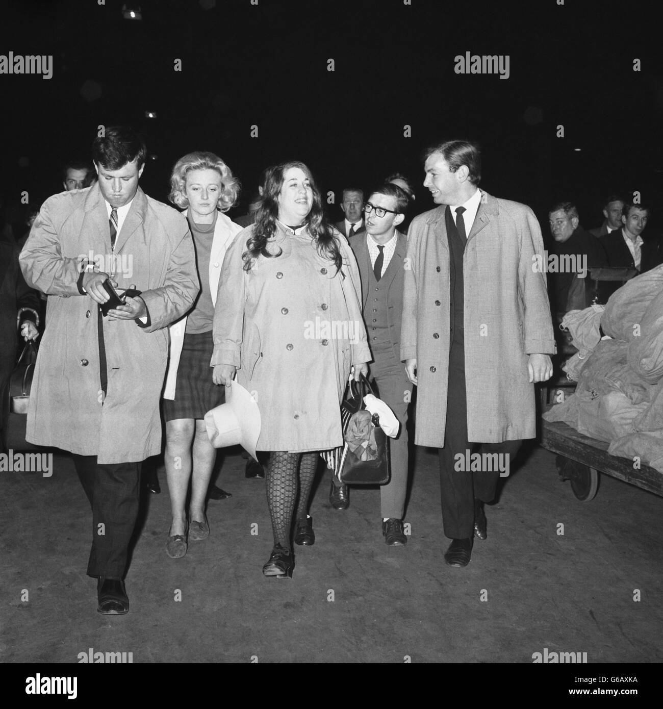 Cass Elliot (centre), singer with American pop group the Mamas and the Papas, on her arrival at Waterloo Station in London. She was escorted from Southampton by two detectives and taken to Kensington police station, where she was charged with stealing articles from a London hotel. Stock Photo